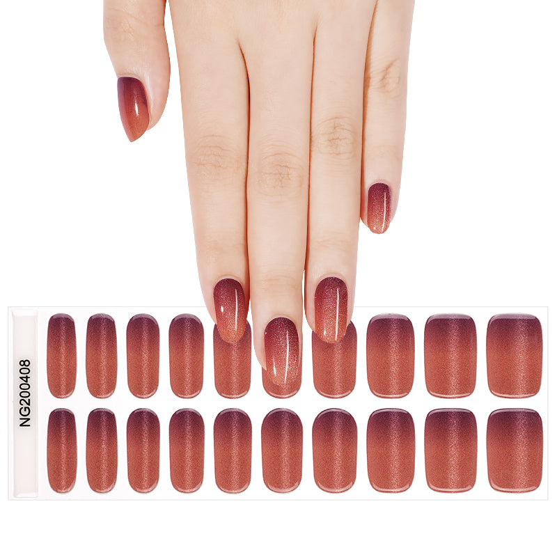 A hand holding a package of 20 semi-cured gel nail wraps. The nails have purple to coral cat eye ombre glitter nail wraps applied.