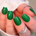 green glitter nail strips on a blurred background