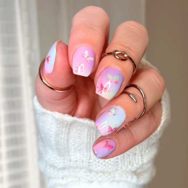 Hand with pastel butterfly nail art stickers