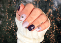 Hand with winer nail stricps in navy and grey against a blurred background