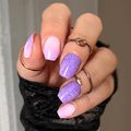 Hand with purple and pink nail polish strips wearing a black sleeve.