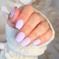 Hand with light purple nail polish wraps wearing a white knit sleeve.