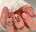 Nails with reindeer design and rings on a neutral background