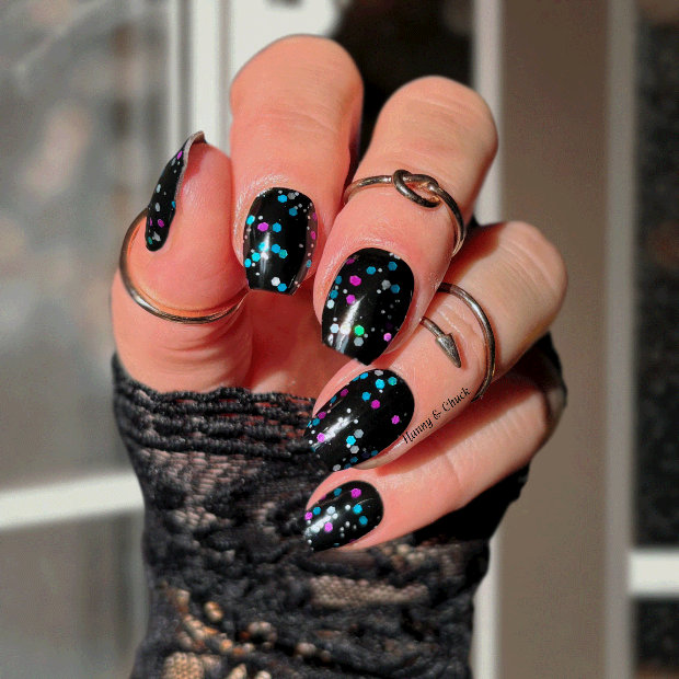 Hand with black glittery nail polish wraps wearing a textured sleeve.