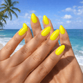 Nails with bright yellow nail polish strips with a beach background 