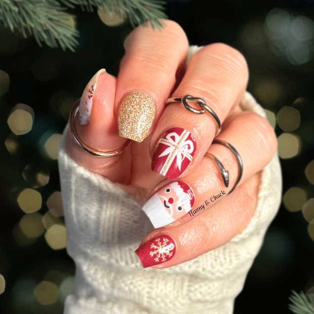 Hand with Christmas-themed nail art against a festive background