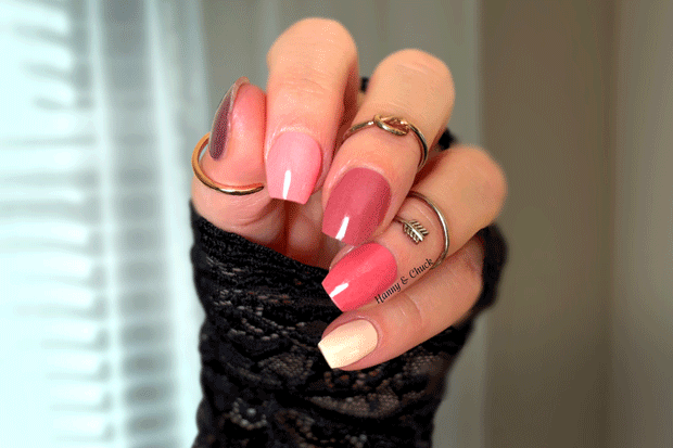 Hand with pink ombre nail polish wraps wearing black textured sleeve