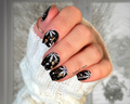 Hand with black and white nail art stickers wearing a white sleeve