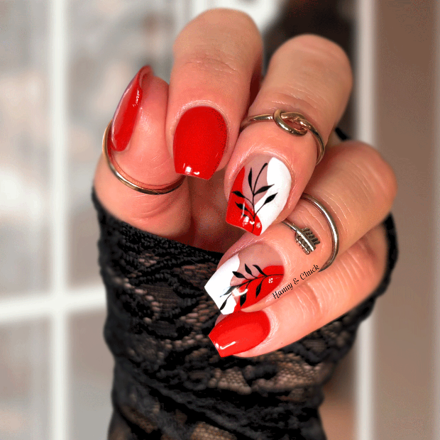 Hand with red and white nail art holding a black woven object.