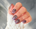 Hand with glittery purple nail stickers on a blurred background