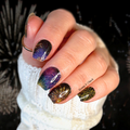 Close-up of a hand with multicolored fireworks nail art stickers against a dark background