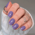 Aged Lavender purple nail wraps on a hand wearing a white sweater