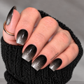 Black and silver glitter ombré nail wraps with fine silver sparkle fading from black cuticles to silver tips, shown on a hand wearing a black knit sleeve.