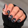 Bone to Be Wild Halloween nail wraps with black cats, skeletons, bats, pumpkins and spiderwebs on a black manicure.
