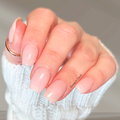 Hand wearing sheer pink glow in the dark nail wraps with a glossy natural finish