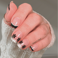 Darkly Daisy French tip nail wraps with black and white floral design and gold glitter centres on hands