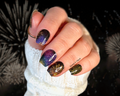 Close-up of a hand with multicolored fireworks glitter nail wraps against a dark background