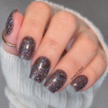Dark brown holographic glitter nail wraps on short square nails, displaying iridescent sparkle, paired with a white sweater and gold ring