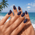 Glossy blue nail wraps photographed against a sunny tropical beach backdrop