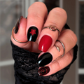 Close-up of a hand with red and black nail polish wearing a black glove.