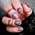 A close-up image of a person's hand showcasing nail wraps with a glittery holographic leopard print design in multicolor.