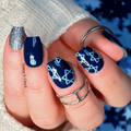 Navy blue nail wraps with silver star designs and a glitter accent nail by Hanny & Chuck.