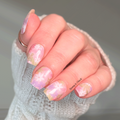 Hand with pink floral nail polish wraps on short square nails with soft pastel flowers, spring nail wrap design, easy at home manicure strips