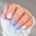 Hand wearing Silver Lining blue and pale pink nail polish wraps with silver glitter accents.