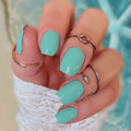 Glossy turquoise nail wraps on short square nails with gold rings, summer manicure