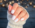 Hand with white nail stickers against a blurred starry background