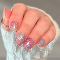 Hand wearing Wildflower Wishes glitter floral nail wraps with colourful pink, purple, blue, and silver sparkle.